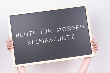 Jugendliche hält eine Tafel hoch auf der 