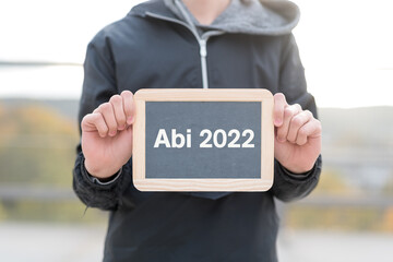 Schüler mit einer Tafel ABI 2022