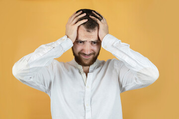 The young man has a headache, he holds his head and suffers, he had a hard day at work, many business meetings