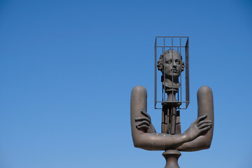 Lacoste, Provence, France. August 08, 2021. Statue of Marquis de Sade on the blue sky background. Head in a cage. The terms "sadist" and "sadism" are derived from his name.