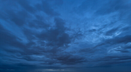 Dramatic dark blue clouds sky with thunder storm and rain at night. Abstract nature landscape background.