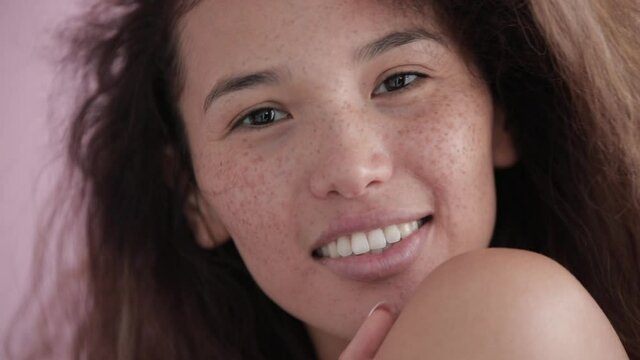 Slow motion portrait of a beautiful woman with curly hair and freckles on her face. natural beauty concept.