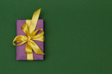 Gift box with ribbon on paper background.