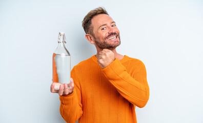middle age man feeling happy and facing a challenge or celebrating. water bottle concept