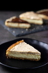 Cheesecake of white chocolate cream and peanut on black plate