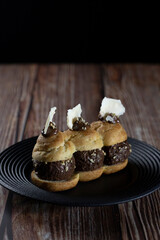 Chocolate cream Eclair on black plate