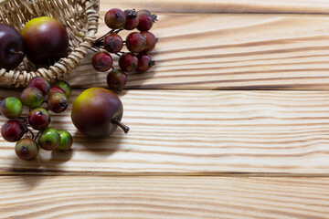 apple, berries and basket on rustic wooden background. Autumn background. Thanksgiving. Food background. Copy space