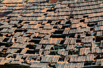 Roof of an old abandoned house with broken and fallen tiles
