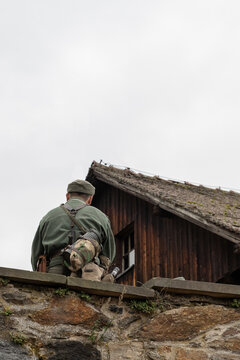 Soldat auf der Mauer sitzend, Blick von hinten. Zweiter Weltkrieg. Foto in hoher Qualität.