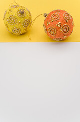 Christmas time paper mache decoration balls on a white yellow background
