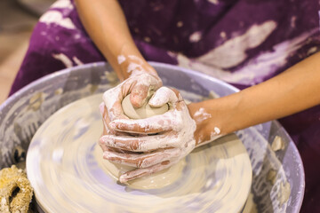 Pottery workshop. Female ceramic artist molding clay on pottery wheel. Creative handmade craft.