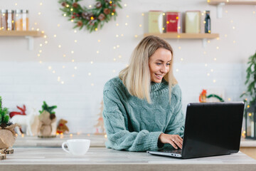 Business woman working at home on laptop during Christmas and New Year, happy and successful completes a big project