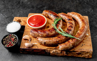 grilled sausages with spices on a stone background 