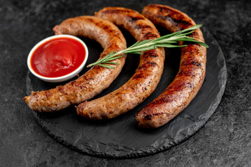 grilled sausages with spices on a stone background