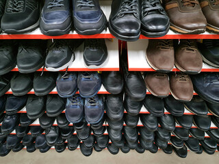 The Sale of footwear. Men's shoe store. Shoe shelves.