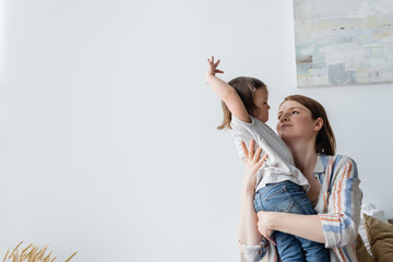Mother looking at child with down syndrome at home.