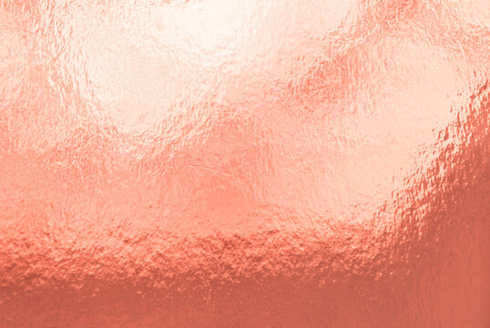 Full frame pink gold background, texture. Gold foil background with light reflections. Beautiful transition of shades. 