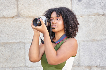 portrait of a young woman taking a photograph with a reflex camera