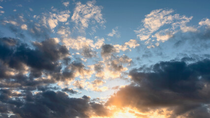 blue sky with clouds beautifully illuminated by the setting sun as a natural background