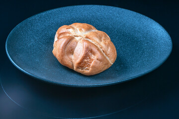 fresh sweet bun on a dark plate