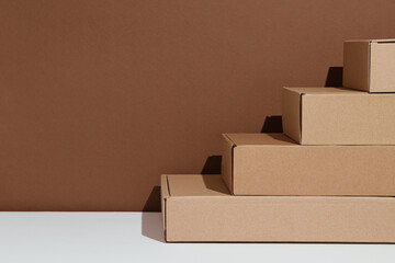 Stairs made with boxes on a brown white background. The concept of progress.