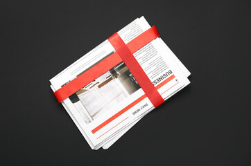 Newspaper with red ribbon on dark background