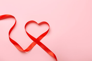 Heart made of red ribbon on color background