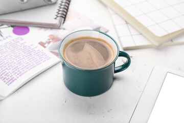 Cup of coffee and stationary on light background