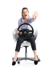 Shocked young woman with steering wheel sitting in chair on white background