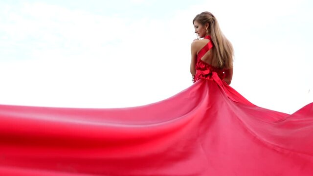 BAckside view of young gorgeous woman in long red dress 