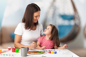 Smiling mother with little child drawing, spending leisure time together