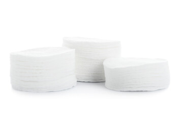 Stacks of new cotton pads on white background