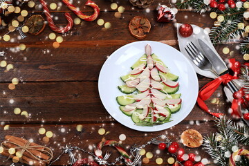 Christmas new year dishes, traditional festive cucumber and radish salad for vegan food, fir branches and cones and decorations, food design idea, place for recipe, flat lay,