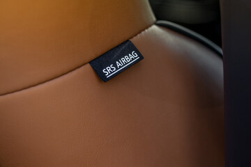 Close up view of airbag label on the side of a car seat. Airbag safety system symbol on the car seat. Modern car interior details.