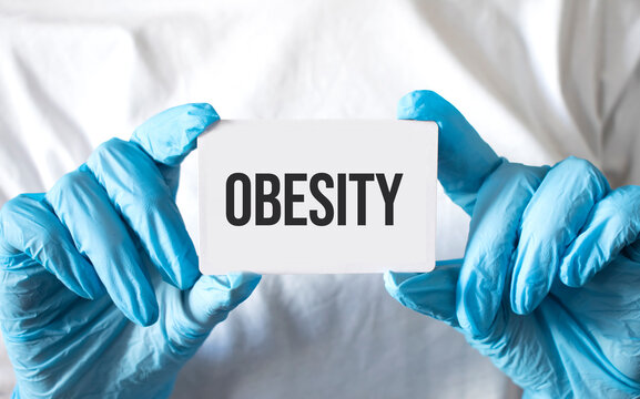 Doctor Holding A Card With Text Obesity, Medical Concept