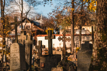 Fototapeta na wymiar Crosses on a tombstones at a cemetery in autumn