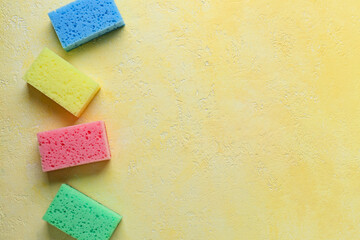 Different cleaning sponges on color background