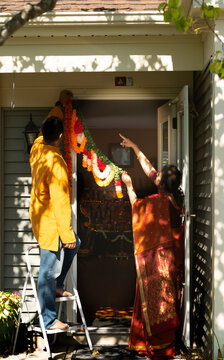 Indian couple decorating home for Diwali 