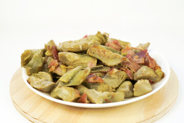 delicious plate of Artichokes with ham and bacon with white background  