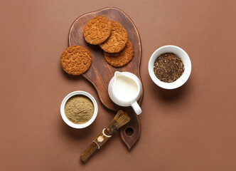 Wooden board with tasty hojicha cookies, powder and chasen on brown background
