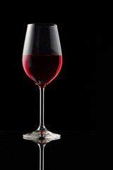 A glass of red wine on a glossy table.