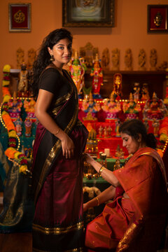 Mother helping daughter with sari 