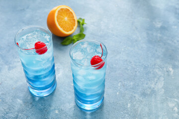 Glasses of Blue Lagoon cocktail on color background