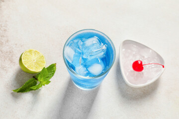 Glass of Blue Lagoon cocktail on light background, closeup