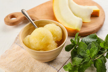 Bowl with tasty melon sorbet and mint on light background