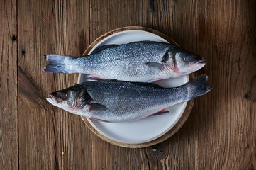 Fresh raw fish seabass on ristic wooden background