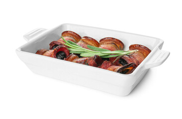 Baking dish with prunes in crispy bacon on white background