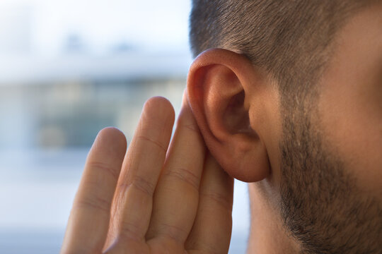 Young man with hearing problems, hearing loss or hard of hearing