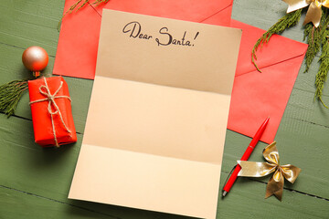 Blank letter to Santa, envelopes and Christmas decor on color wooden background