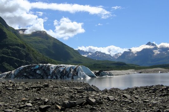 chugach mountain peaks and a rocky glacial lake in valdez lake glacier on a sunny summer day  in southeastern alsaka